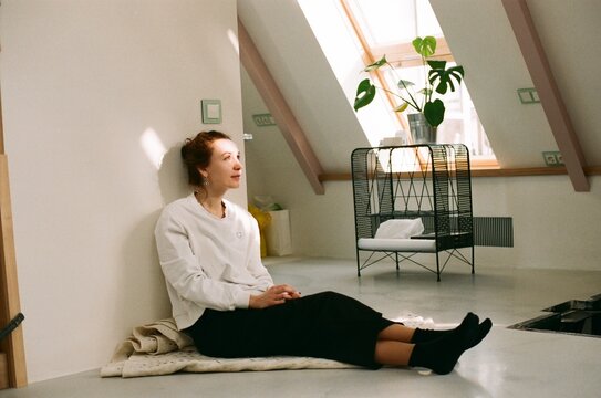 Woman sitting on a floor in a attic