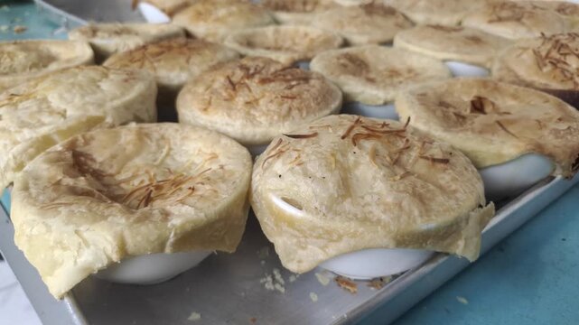 Close up of bowls filled with delicious zuppa soup. Zuppa soup is a thick Italian cream soup or zuppa toscana that is uniquely served with a crispy pastry lid on top of the bowl.