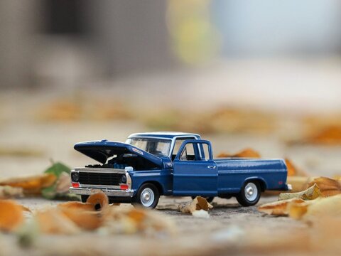 Diecast photography with blue pickup. Unfocus view at land. Background is bokeh and blurred. Toy photography concept.