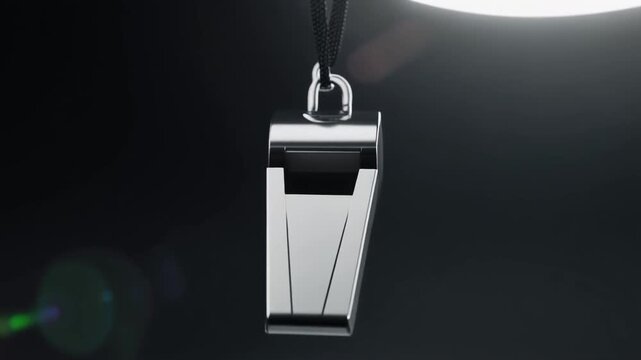 The Metallic Whistle. Premium Football Gear on Dark Studio Background. Performance Branding. Polished gunmetal whistle hanging from a black paracord, set in a dark studio with a sharp white rim light
