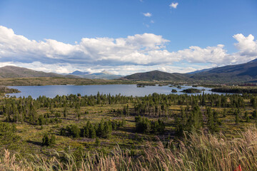Summer Mountain Reservoir with Green Forest and Clouds