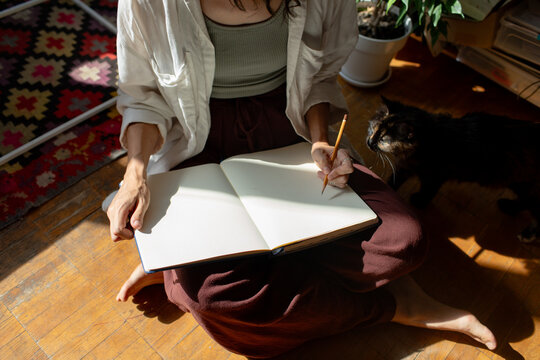 the woman is sitting  and drawing  in the room