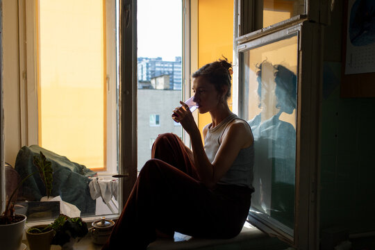 a woman sits on the windowsill in the room