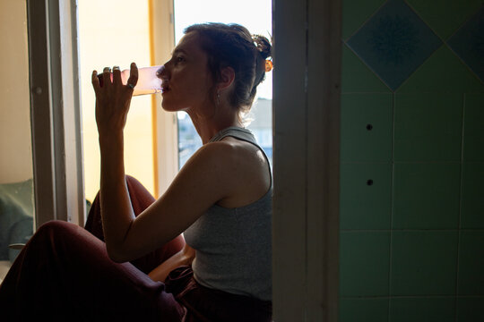 a woman sits on the windowsill in the room