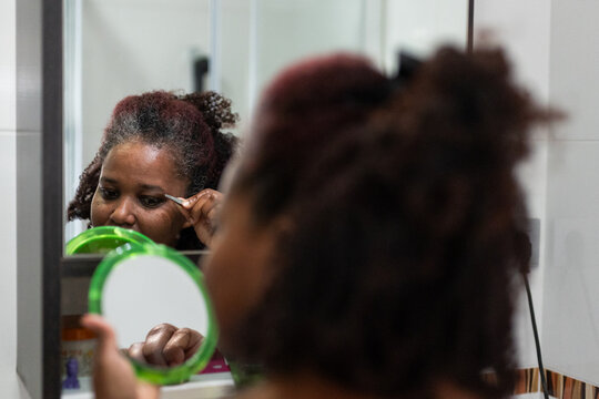 a woman removing hair from her eyebrows