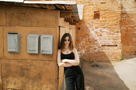 Environmental Portrait of young brunette woman in the old courtyard