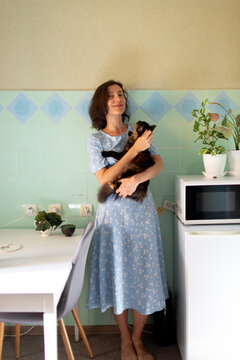 a woman with a cat in the kitchen