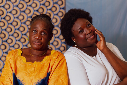 Mother and daughter sitting side by side in a studio