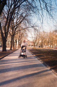 Mum Walking with Stroller in CIty Park in Spring  - film analog