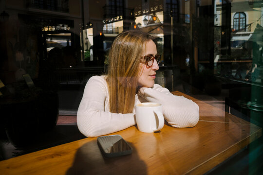  Woman gazing out caf&eacute; window 