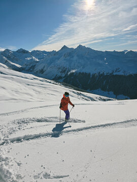 Skier In Deep Snow On Beautiful Snowcapped Mountains 