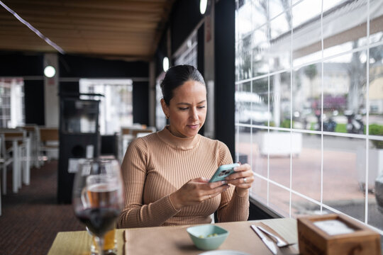 Woman using mobile phone in a restaurant