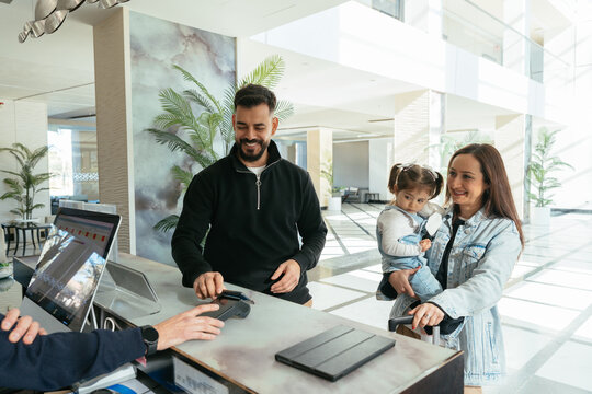 Family paying at hotel reception using credit card