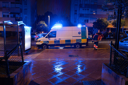 Ambulance with flashing lights parked on city street