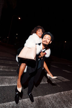 Friends at night piggy riding in the street