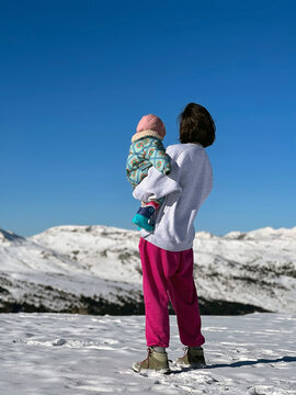 Mother Enjoys Snowy Mountain View With Baby