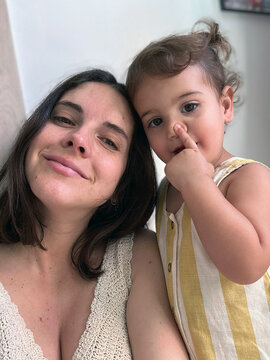 Selfie of Smiling Mother and Child with a finger on their nose