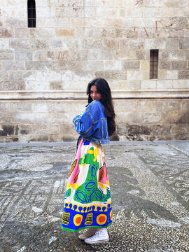 Young Woman in Colorful Dress Poses Outdoors