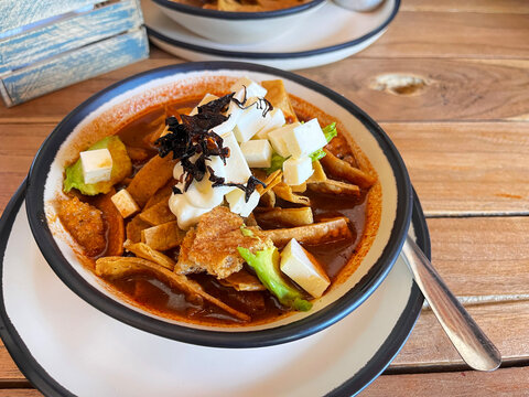 Sopa de tortilla o azteca servida con queso, aguacate, crema y chile chipotle