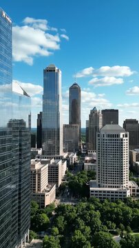 Modern Glass Skyscraper Office Buildings With Lush Green Trees And Blue Sky In Downtown Cityscape