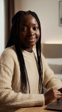 Young Woman With Braided Hair Typing On Laptop Keyboard In A Cozy Room Wearing A Cream Sweater With Soft Lighting