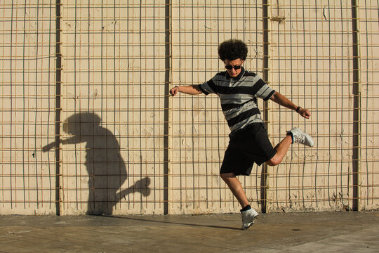 Latino dancer dancing in a sunny street