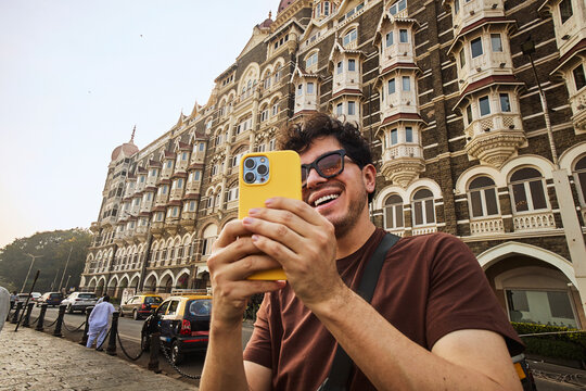 Man taking photos with his mobile phone in the streets of Mumbai