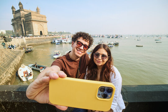 Friends taking a selfie with Gateway of India and sea view in Mumbai