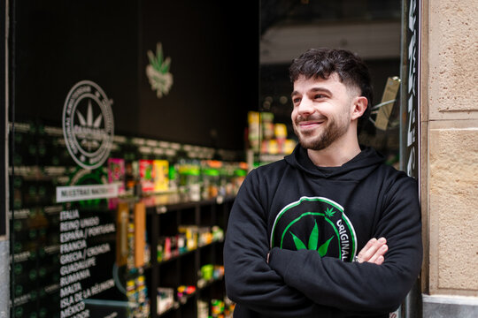 Relaxed CBD shop worker standing at store entrance