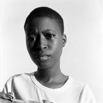 Monochrome portrait of woman with short hair applying lipstick 