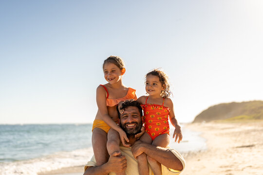 Kids playing with their dad at the beach
