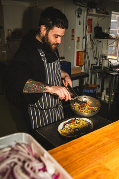 Wide shot of chef plating dish