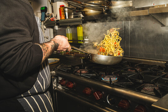 Chef Tossing Pasta in Pan