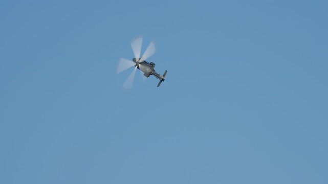 LUQA, MALTA - SEPTEMBER 28, 2025: Video of a military helicopter performing impressive aerobatic maneuvers. The aircraft banks sharply and flies against a clear blue sky, demonstrating its agility and