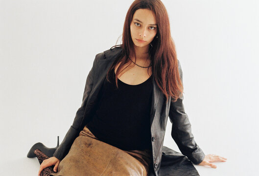 Portrait of a woman in a stylish outfit against a neutral background