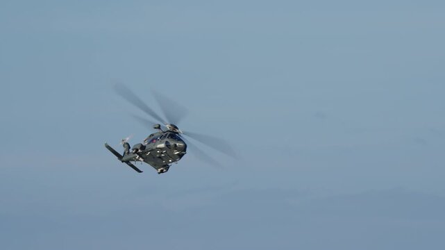 LUQA, MALTA - SEPTEMBER 28, 2025: Video footage of an Italian Air Force HH-139A military helicopter performing a sharp banking turn against a clear blue sky. The clip follows the aircraft as it