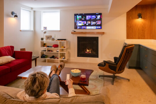 Senior citizen watch tv at home fireplace 