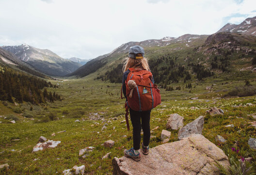 Hiker kid with backpack looking at mountains