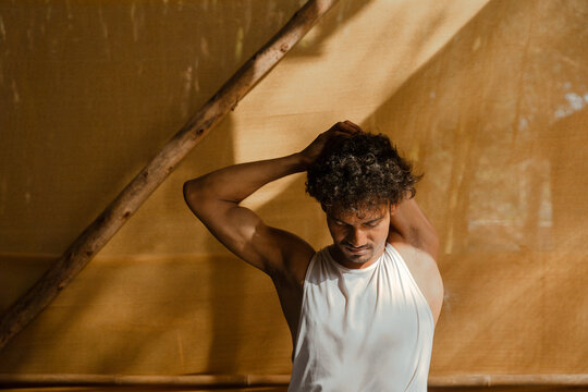 Man Stretching Neck Forward with Hands Behind Head