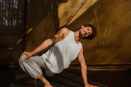 Man Practising Seated Side Stretch in Natural Light