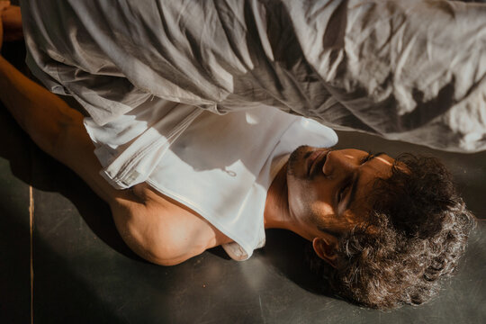 Man Preparing for Shoulder Stand Yoga Pose on Mat