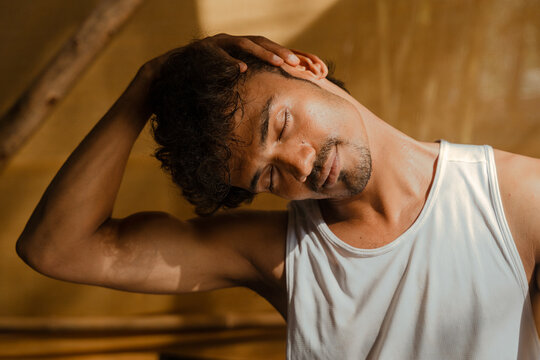 Man Doing Neck Stretch Exercise in Natural Light
