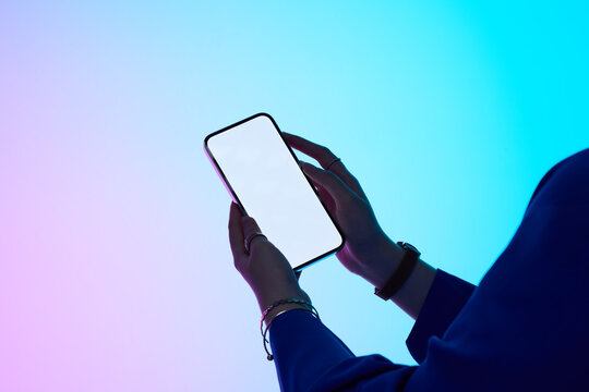 The woman's hands hold a blank smartphone on a gradient background