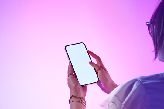 A woman interacts with a modern smartphone showing a blank screen