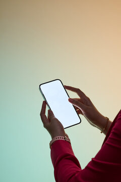 Woman holds a modern smartphone with a blank screen