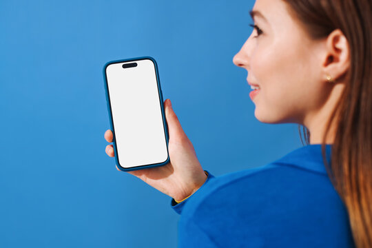 Mockup phone with white screen. Woman Holding Phone on blue background