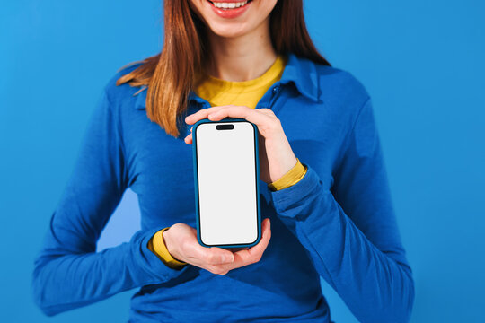 Mockup phone with white screen. Woman Holding phone on blue Background