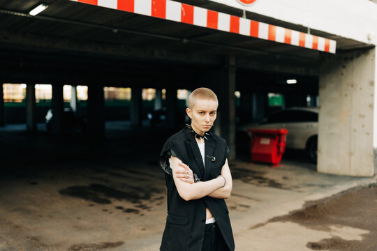 cool woman with short hair standing on the parking