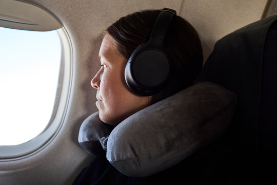 Woman with neck pillow on on the plane
