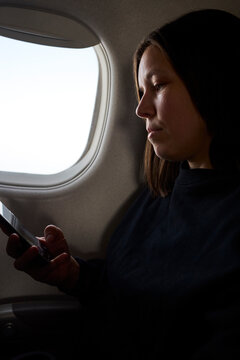 A woman uses phone on her flight